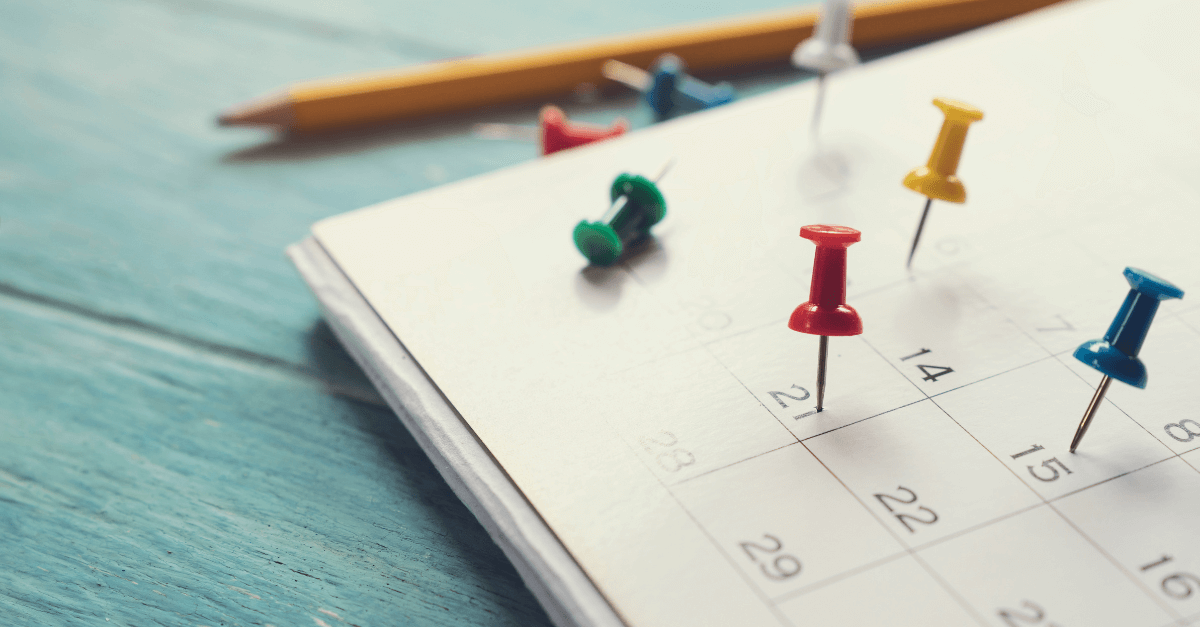 Image of a calendar with colourful pins pinned on 4 different dates